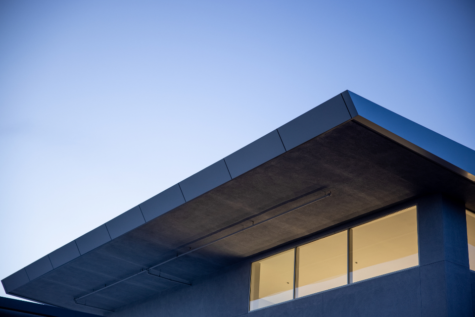 A modern home glowing warmly at dusk